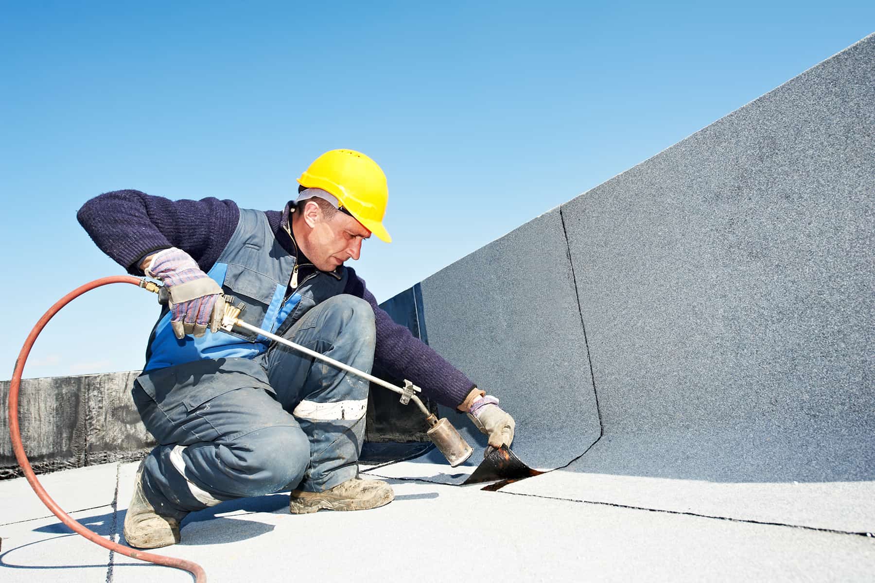 Technician repairing a flat roof on a Chicago building